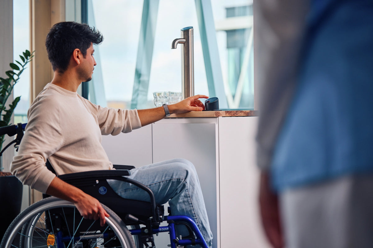 Une personne en fauteuil roulant utilisant le panneau « Easy Access » dans un bureau 