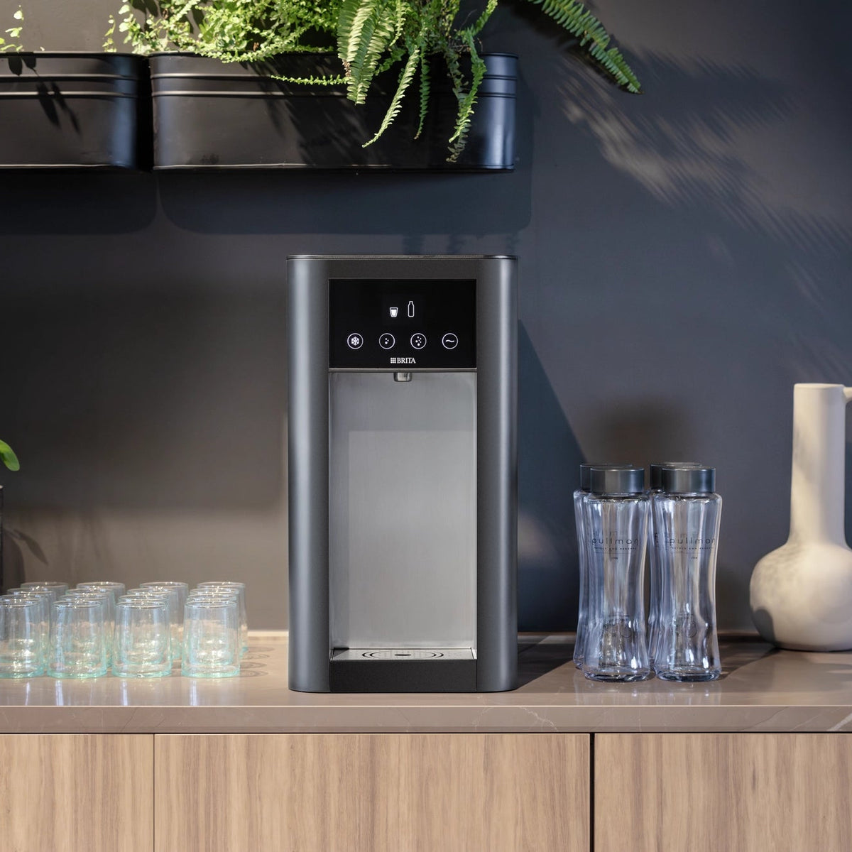 fontaines à eau  Top Pro posé sur un Comptoir de cuisine, avec des verres et des bouteilles, dans une cuisine au style moderne.